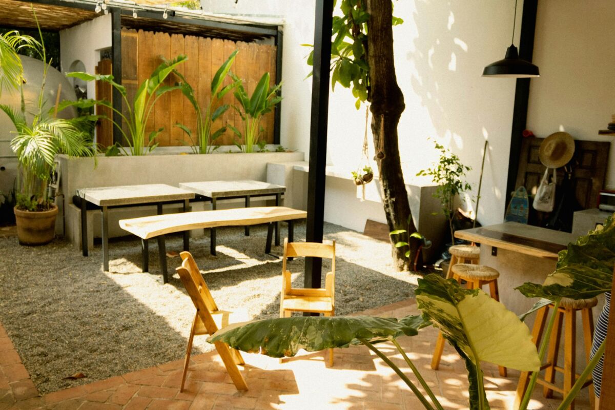 a patio with a table, chairs and a bench, back patio ideas