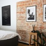 a bedroom with a brick wall and pictures on the wall, Bedroom Accent Wall Ideas