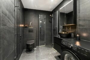 A washer and dryer in a bathroom with a skylight, Dark Bathroom Ideas