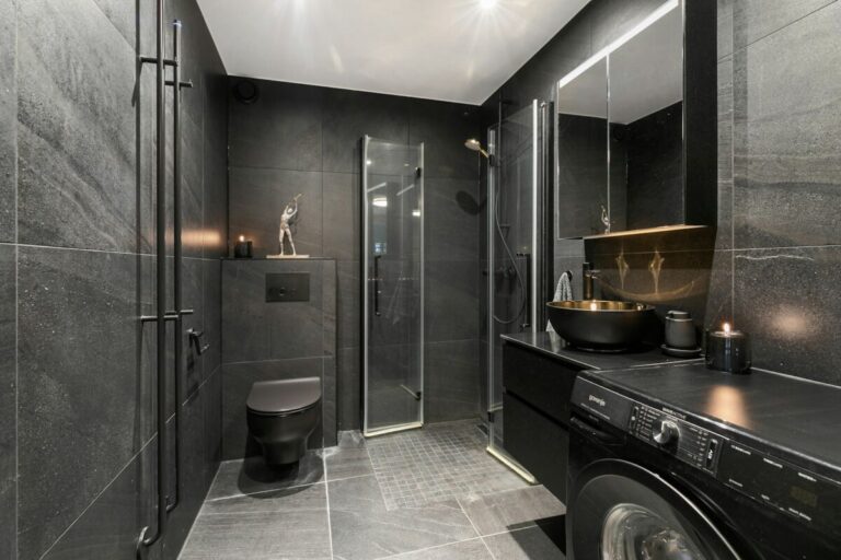 A washer and dryer in a bathroom with a skylight, Dark Bathroom Ideas