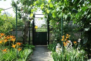 a garden with lots of flowers and a gate, Garden Entrance Ideas