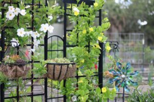 a table with flowers and chairs, Garden Trellis Ideas