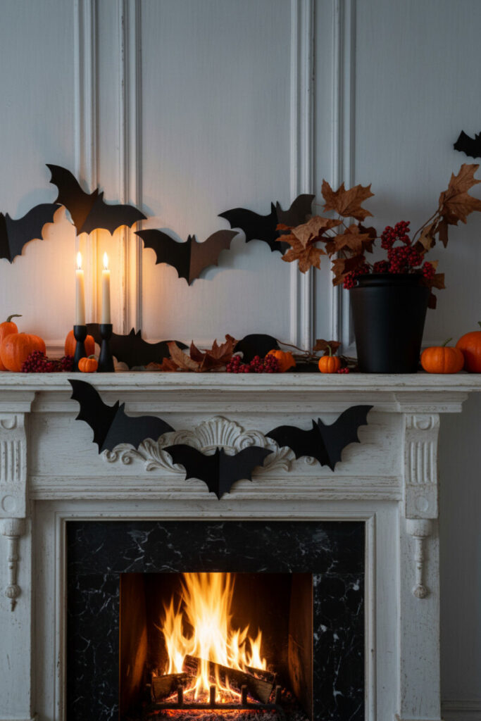 Gray-paneled fireplace surrounded by black paper bats, pumpkins, and flickering fire for moody charm.
