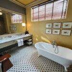 a bathroom with a bathtub, sink, and mirror