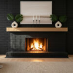 Warm minimalism: perfectly centered matte black brick surround, light oak floating mantel with donut vases and Monstera leaves, horizontal neutral abstract, roaring fire, beige woven rug—showcasing black brick fireplace with wood mantel and floor-to-ceiling black brick fireplace wall.