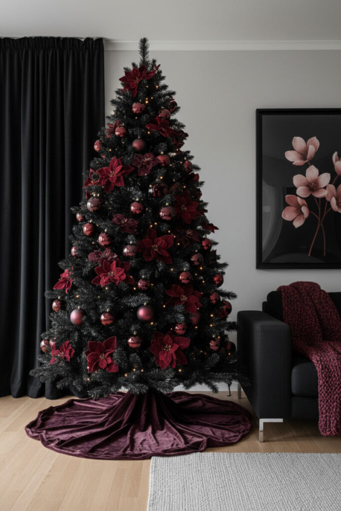 Tall matte-black tree drenched in burgundy velvet poinsettias and maroon baubles with a pooling silk skirt—opulent luxury black Christmas tree decorations for a dramatic lounge.