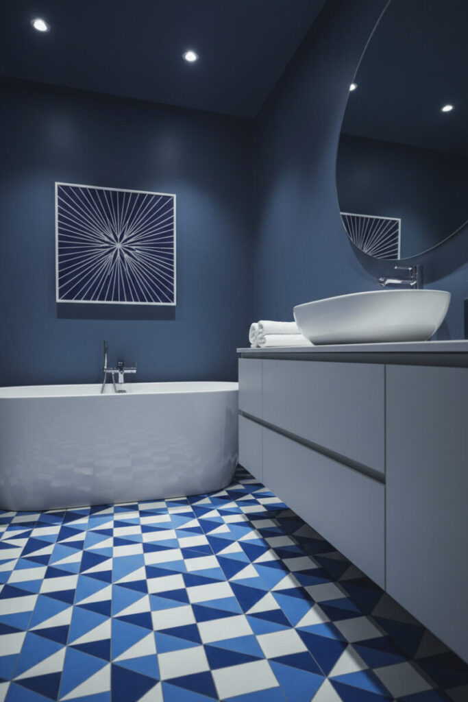Luxurious bath with deep slate blue walls and dramatic blue and white geometric floor tiles, sculptural tub and sink—smart blue bathroom ideas.