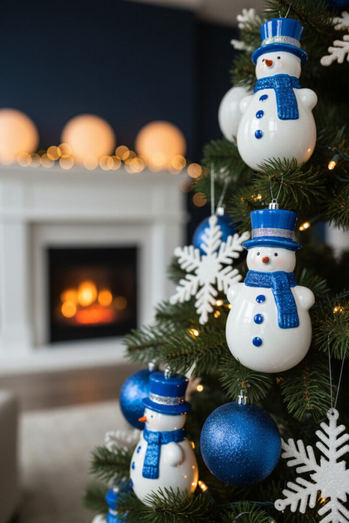 Close-up of white and blue snowmen with cobalt hats and scarves, glittered blue baubles, and warm golden LEDs—playful blue Christmas decor moment.