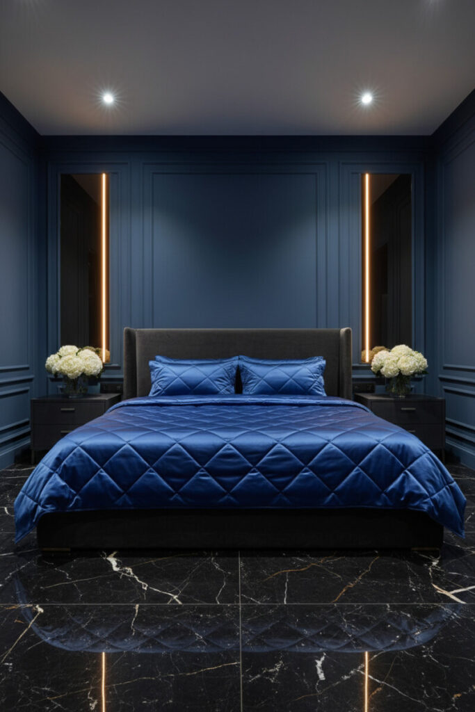 Midnight blue paneled wall with vertical amber LEDs, charcoal velvet bed, sapphire silk bedding, and Nero Marquina marble—editorial Dark Bedroom Designs.