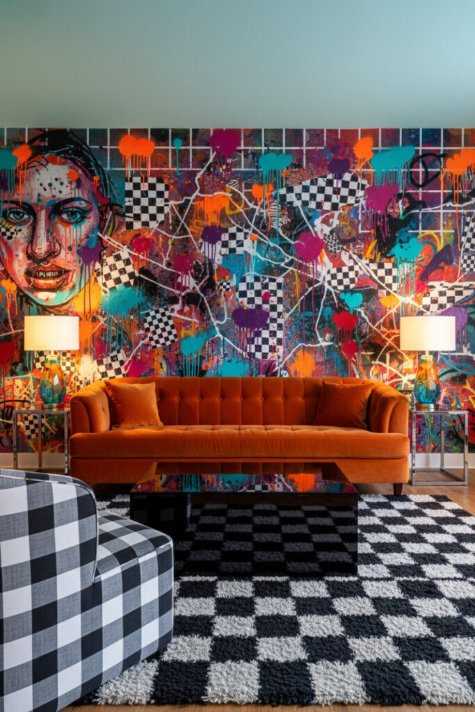 Floor-to-ceiling street-art mural with burnt-orange sofa, buffalo check chair, and glossy black table—Wall Wonder in Funky Living Room Ideas.