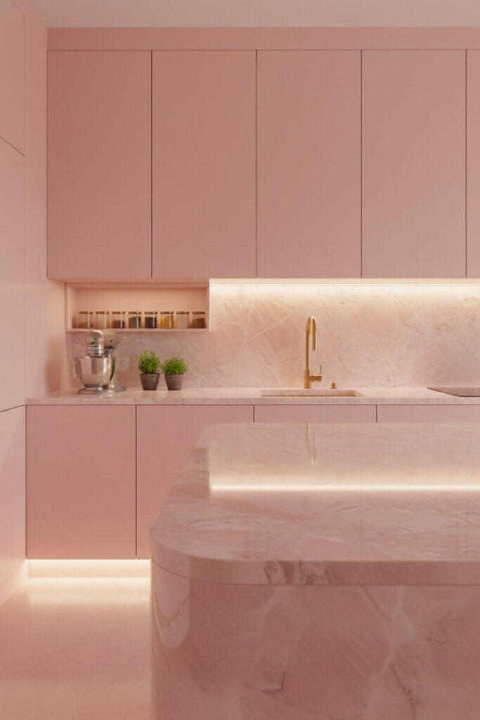 Rose quartz island and backsplash with satin pink lacquer cabinets and brass—luxurious modern pink kitchen.