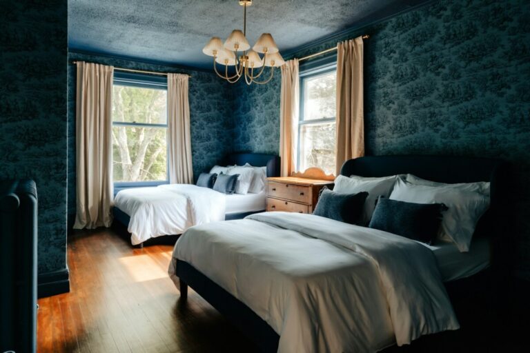 A bedroom with two beds and a chandelier