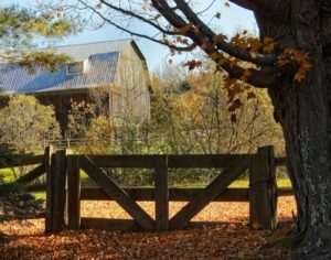 a wooden fence with a barn in the background