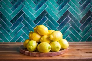 Lemons piled on a wooden plate.