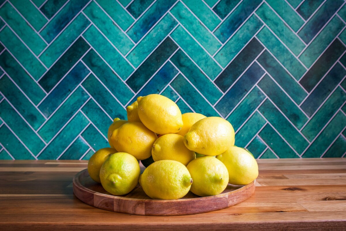 Lemons piled on a wooden plate.