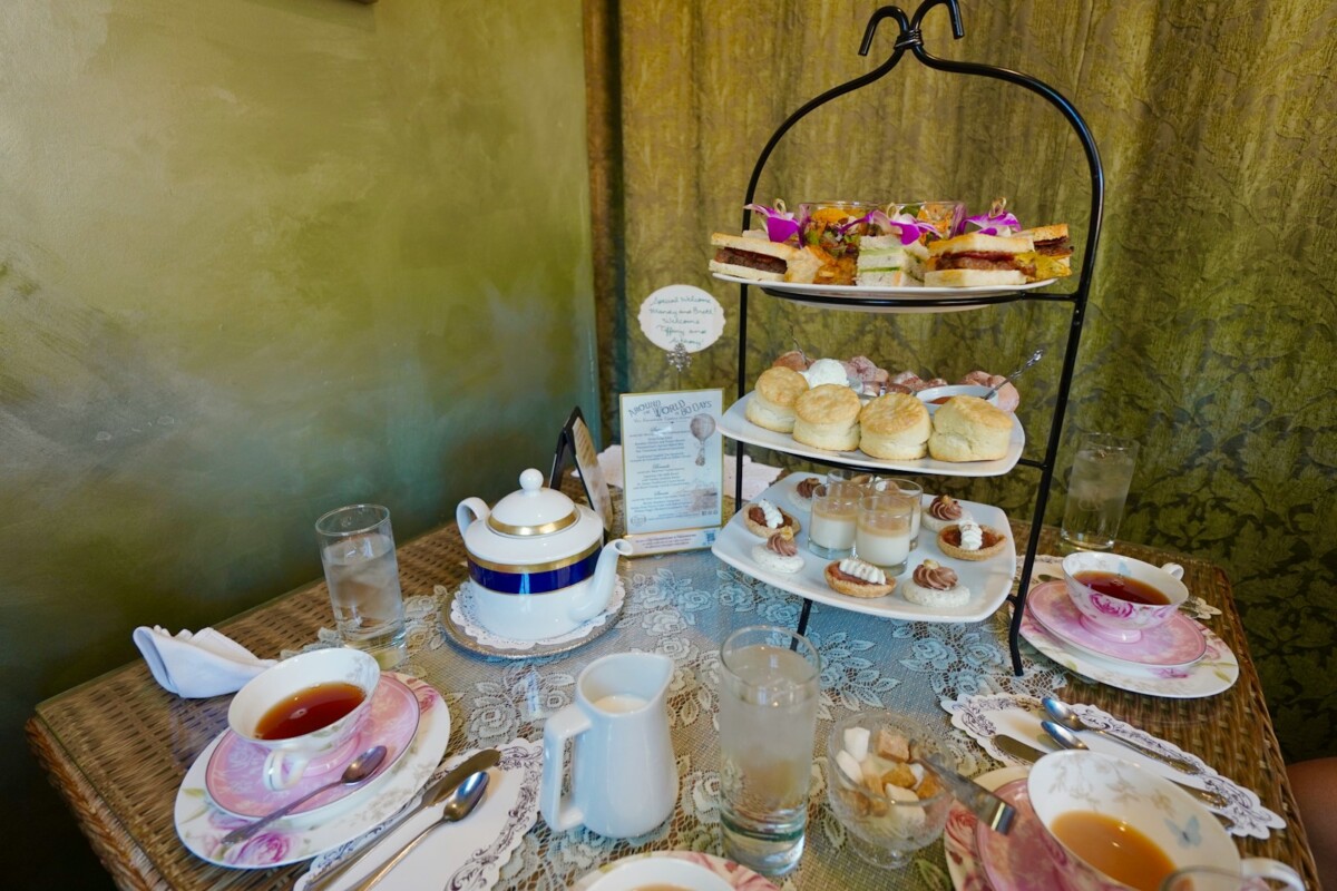 A table topped with plates of food and cups of tea